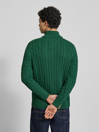 Männermodel trägt Gebreide pullover uit puur katoen met kabelpatroon en ribboorden, Strickpullover aus reiner Baumwolle van Superdry, heren, eng aansluitende pasvorm, schipperskraag, labeldetail, ruglengte maat M 70 cm, mouwlengte maat M 71 cm, donkere groentinten, rechte vormen, zachte gebreide textuur, ganzkörperansicht rückansicht.
