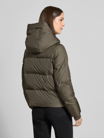 Frauenmodel trägt Regular Fit Daunenjacke mit Label-Patch von Marc O'Polo in Oliv, gesteppt, glänzende Textur, Ganzkörperansicht Rückansicht, Damen Daunenjacke von Marc O'Polo.