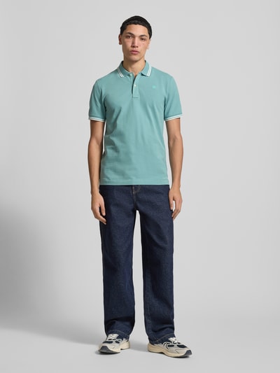 Männermodel trägt Slim Fit Poloshirt mit Logo-Stitching Modell 'Dunda' von G-Star Raw aus elastischem Baumwoll-Mix, Ganzkörperansicht von vorne.