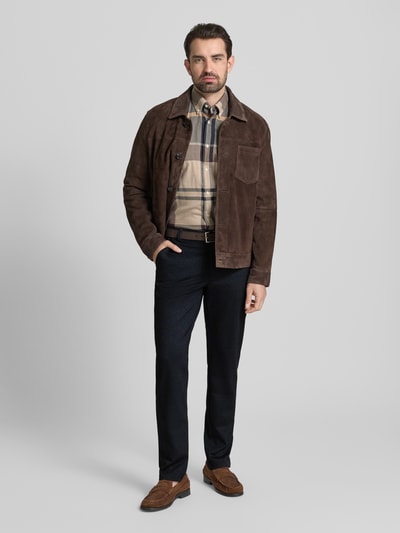 Männermodel trägt Regular Fit Stoffhose mit Viskose-Anteil von Christian Berg Men, dunkler Farbton, Elastischer-Material-Mix, Eingrifftaschen, Gesäßtaschen, Knopf-Reißverschluss, Bundweite 46 cm, Innenbeinlänge 87 cm, Ganzkörperansicht von vorne.