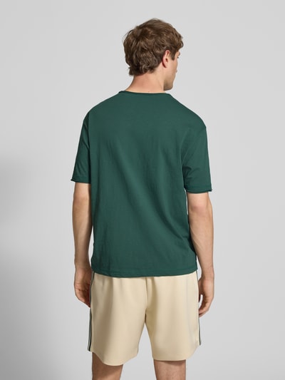 Männermodel trägt Relaxed Fit T-Shirt aus reiner Baumwolle von Marc O'Polo Denim in Optik: Unifarben, Passform: Relaxed-Fit, Rundhals, Ärmelform: Kurzarm, Raw Cut Saum, Material: Reine Baumwolle, Ganzkörperansicht Rückansicht.