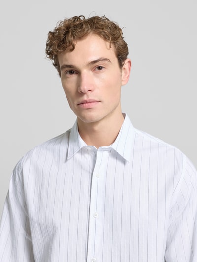Männermodel trägt Freizeithemd mit Knopfleiste von Samsøe Samsøe, Bio-Baumwoll-Mix, Regular-Fit, Kentkragen, Nahaufnahme Oberkörper.