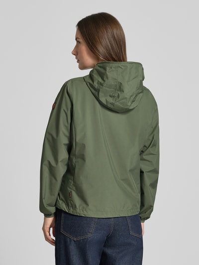 Modelka kobieca nosi Regular Fit Jacke mit Zweiwegereißverschluss Modell 'Stella' od SAVE THE DUCK w kolorze oliwkowym, gładka tekstura, kurtka damska z zamkiem dwukierunkowym, kieszenie na zamek, długość pleców w rozmiarze S: 60 cm, szerokość ramion w rozmiarze S: 42 cm, szerokość w rozmiarze S: 52 cm, długość rękawa w rozmiarze S: 64 cm, widok całej sylwetki od tyłu.