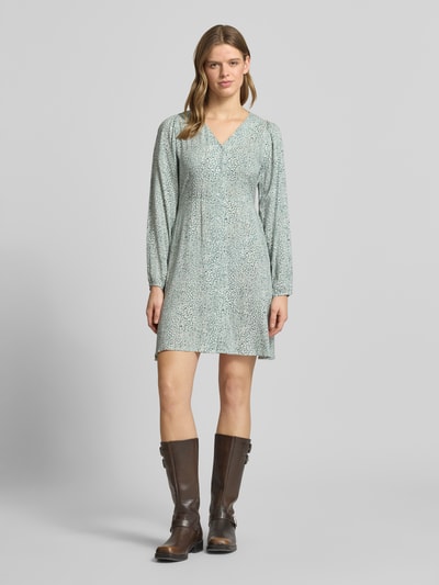 Frauenmodel trägt tailliertes Freizeitkleid aus reiner Viskose Modell 'EVIDA' von Only, Optik: Allover-Muster, Mini-Länge, V-Ausschnitt, Knopfleiste, Ballonärmel, Knopf mit Öse, Ganzkörperansicht von vorne.