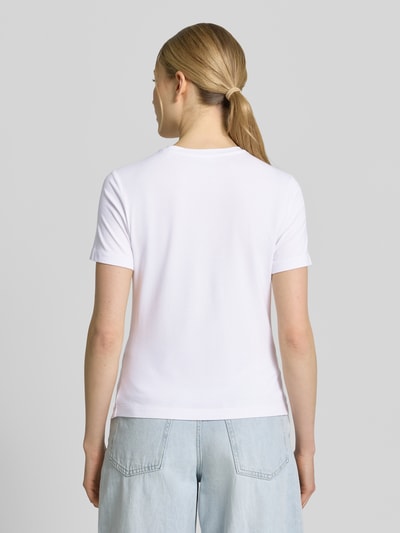 Vrouwenmodel draagt T-Shirt uit viscose-elastaanmix met logo van Guess Activewear, regular fit, ronde hals, ruglengte maat S 53 cm, wit, gladde textuur, geheel zicht van achteren.