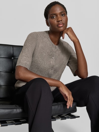 Kobiece model prezentuje Regular Fit Cardigan in Strick-Optik Model 'Iga' od VILA, elastyczna mieszanka materiałów, krój regular fit, rękaw o dł. 1/2, imitacja dzianiny, listwa guzikowa, długość tyłu w rozmiarze S: 50 cm, długość rękawów w rozmiarze S: 32 cm, widok całej sylwetki z przodu.