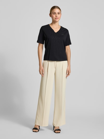 Frauenmodel trägt T-Shirt mit Strasssteinbesatz und V-Ausschnitt von LIU JO SPORT in Schwarz, reine Baumwolle, gerader Schnitt, Ganzkörperansicht von vorne.