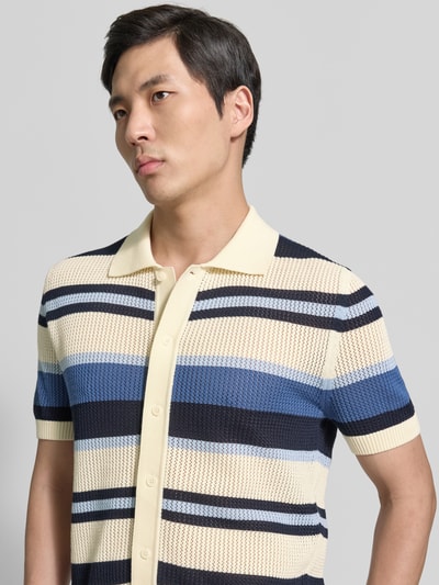 Mannelijk model draagt Slim Fit Poloshirt in tricotlook van Gant, puur katoen met polokraag, korte mouw en knoopsluiting, Nahaufnahme Oberkörper.