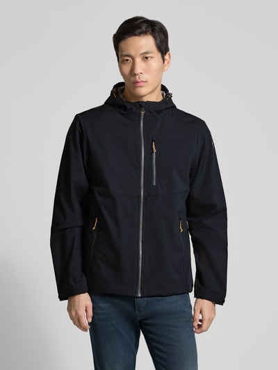 Męski model nosi Regular Fit Jacke mit mit Logo-Applikation von Killtec, kolor czarny, kaptur z tunelem, widok całej sylwetki z przodu. Długość pleców w rozmiarze M: 72 cm, szerokość ramion w rozmiarze M: 45 cm, szerokość klatki piersiowej w rozmiarze M: 57 cm, długość rękawa w rozmiarze M: 67 cm, kieszenie z zamkiem, napoleońska kieszeń.