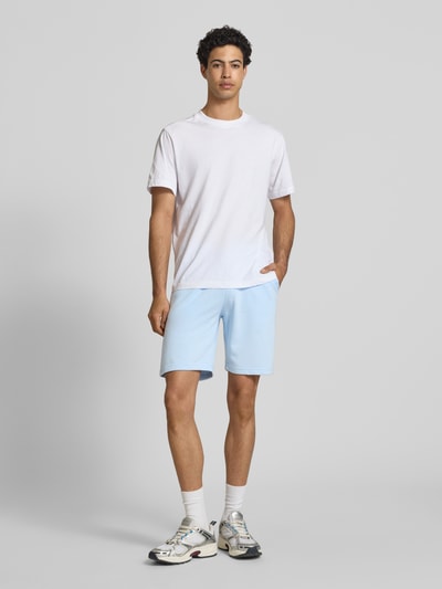 Męskimodel nosi Sweatshorts mit elastischem Bund Modell 'KARLOS' von Blend, mieszanka bawełny, krój regular fit, szerokość w rozmiarze M 42 cm, długość wewnętrzna nogawki w rozmiarze M 21 cm, jasnoniebieskie, z tunelem; widok całej sylwetki z przodu.