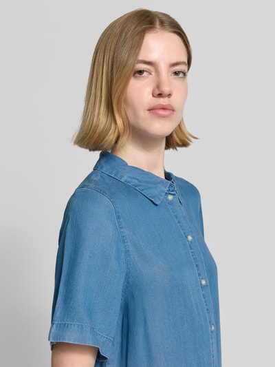 Frauenmodel trägt Tailliertes Jeanskleid aus Lyocell Modell 'BREE' von Vero Moda in Denim-Optik, Kurzarm, Knopfleiste, Mini-Länge, Nahaufnahme Oberkörper.