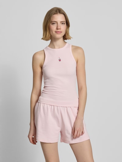 Frauenmodel trägt Tanktop mit Rundhalsausschnitt von REVIEW in zartem Rosa, Baumwoll-Elasthan-Mix, Feinripp, eng anliegende Passform, Ganzkörperansicht von vorne.