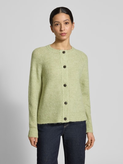 Vrouwenmodel draagt Regular Fit Strickjacke aus Woll-Mix mit Alpaka-Anteil Modell 'LULU' van Selected Femme, unikleuren look, ronde hals, lange raglanmouwen, eenrijige knoopsluiting, gebreid materiaal. Vooraanzicht van het hele lichaam.