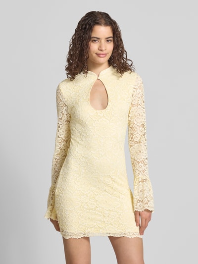 Frauenmodel trägt Slim Fit Minikleid mit Allover-Spitzenbesatz von Gina Tricot in Gelb mit Stehkragen und Schlüsselloch-Ausschnitt, Nahaufnahme Oberkörper.