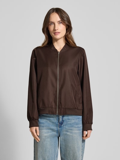 Modelka kobieca ma na sobie Regular Fit Bomberjacke mit Stehkragen Modell 'Papaya' od Vila, brązowy kolor, boczne kieszenie, zamek, elastyczne wykończenia, krój regular fit, długość tyłu w rozmiarze 36: 48 cm, szerokość ramion w rozmiarze 36: 38 cm, szerokość klatki piersiowej w rozmiarze 36: 50 cm, długość rękawa w rozmiarze 36: 63 cm, widok całej sylwetki z przodu.