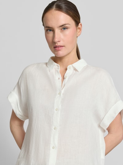 Frauenmodel trägt Leinenbluse mit Knopfleiste Modell 'DOLLY' von 0039 Italy in Weiß, reine Leinen-Qualität, Regular-Fit, Hemdblusenkragen, Ärmel mit Aufschlag, Rückenlänge 64 cm bei Größe S, Nahaufnahme Oberkörper.