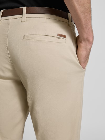 Männermodel trägt Slim Fit Stoffhose mit abnehmbarem Gürtel Modell 'Marco' von JACK & JONES, Beige, Baumwoll-Mix, Detailaufnahme Rückansicht, Gesäßtasche sichtbar, Bundweite und Innenbeinlänge gemäß Kontext.