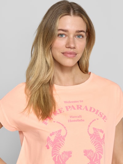 Frauenmodel trägt Regular Fit T-Shirt mit Motiv-Print von Milano Italy in Pfirsich, Reine Baumwolle, Rundhalsausschnitt, Nahaufnahme Oberkörper, Rückenlänge bei Größe S: 56 cm.