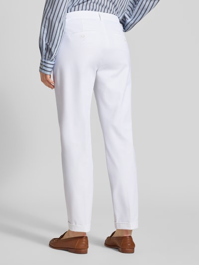 Frauenmodel trägt Chino aus Techno Cotton Superstretch Modell 'UTE' von Raffaello Rossi, Straight Fit, verkürzte Passform, Weiß, Ganzkörperansicht Rückansicht. Elastischer-Material-Mix mit Baumwoll-Anteil, Knopf- und Reißverschluss, Eingriff- und Gesäßtaschen, Bügelfalten, fixierte Beinumschläge, Gürtelschlaufen, Bundweite bei Größe 36: 40 cm, Innenbeinlänge 68 cm.