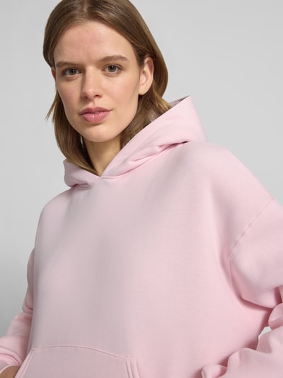 Vrouwenmodel draagt Regular Fit Hoodie met kangoeroezak model 'Iconic' van Gina Tricot, katoenmix, dames, detailopname bovenlichaam.