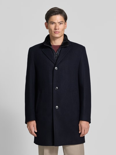 Männermodel trägt Regular Fit Mantel aus Woll-Mix von HECHTER PARIS in Dunkelblau, Reverskragen, Knopfleiste, Ganzkörperansicht von vorne, Kontext: Herren Mantel, Rückenlänge Größe 50: 95 cm, Schulterbreite: 43 cm, Brustweite: 57 cm, Ärmellänge: 67 cm.