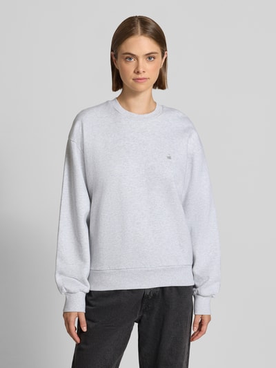 Vrouwenmodel draagt lichtgrijze sweatshirt uit puur katoen Model 'Casey' van Carhartt Work In Progress, losse pasvorm, dames, met geribde boorden, schouders verlaagd, voorkant volledig zichtbaar, Ganzkörperansicht von vorne.