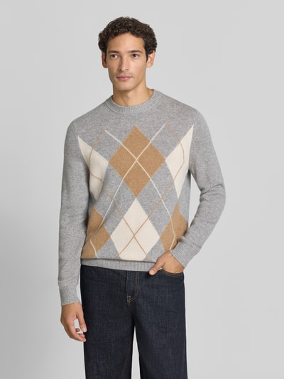 Männermodel trägt Slim Fit Pullover aus reinem Kaschmir in Strick-Optik von Christian Berg Men, graue Jeans, Ganzkörperansicht von vorne. Rückenlänge bei Größe M 70 cm, Ärmellänge 68 cm, Rundhalsausschnitt, dezentes Rautenmuster in Grau, Beige und Creme.