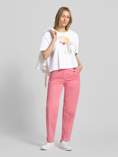 Kobiece modelka nosi T-Shirt mit Motiv-Print und Rundhalsausschnitt von Marc Cain, biała bawełna, krój boxy fit, motyw z cekinami, długość tyłu w rozmiarze 36: 53 cm, jasne kolory, przód pełnej sylwetki.
