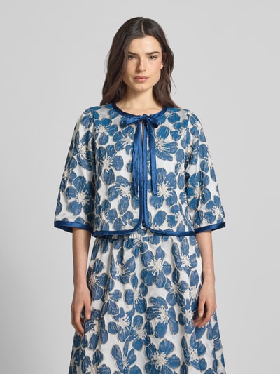 Frauenmodel trägt Jacke mit Schnürung Modell 'Trine' von LOLLYS LAUNDRY, florales Muster in Blau-Weiß, Material-Mix mit Stretch-Anteil, Regular-Fit, 3/4-Arm, Ganzkörperansicht von vorne.