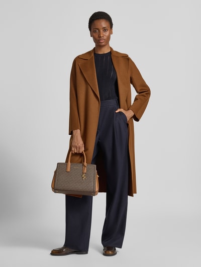 Frauenmodel trägt Handtasche aus Leder mit Logo-Muster Modell 'LAILA' von MICHAEL Michael Kors mit Label-Applikation, Tragehenkel, Schulterriemen, Reißverschluss, Breite 34 cm, Länge 22 cm, Tiefe 13 cm, Länge Schulterriemen 36 cm, Ganzkörperansicht von vorne.