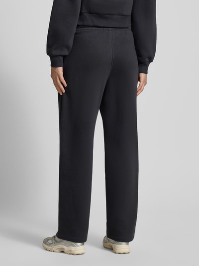 Kobiece modelka nosi High Waist Sweatpants mit elastischem Bund und Logo od JJXX z mieszanki bawełny, szerokie nogawki, logo, widok całej sylwetki z tyłu.