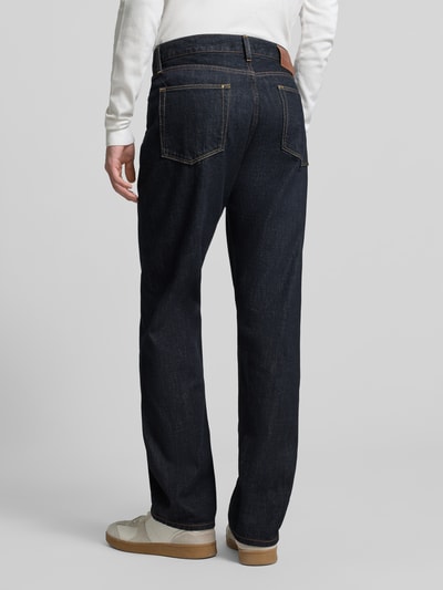Männermodel trägt Straight Fit Jeans aus reiner Baumwolle von Tommy Hilfiger in dunklem Denim mit Label Patch und Gürtelschlaufen, Ganzkörperansicht Rückansicht.