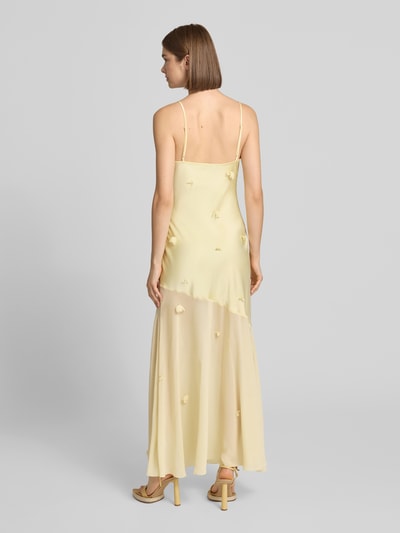 Vrouwenmodel draagt Maxikleid met floralem besatz van Gina Tricot in lichtgele satijn met spaghettibandjes, nauwsluitend, garnering, cascadehals, ruglengte maat 36: 133 cm, borstwijdte maat 36: 34 cm, ganzkörperansicht rückansicht.