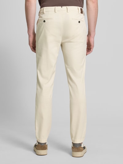 Männermodel trägt Slim Fit Hose mit Eingrifftaschen Modell 'Tybalt 5' von g1920 aus Baumwoll-Lyocell-Mix in Beige, Ganzkörperansicht Rückansicht.