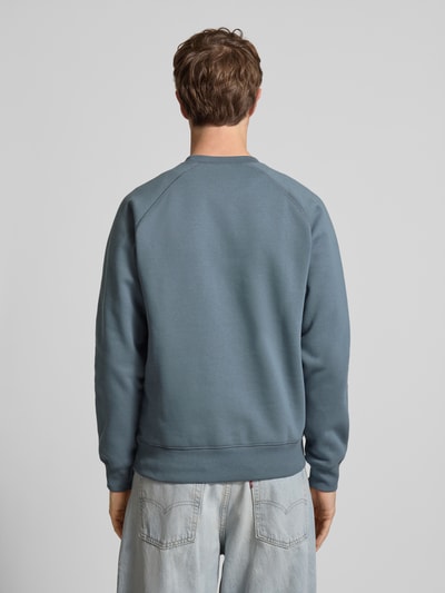 Männermodel trägt Regular Fit Sweatshirt mit Rundhalsausschnitt Modell 'Chase' von Carhartt Work In Progress in Blau, Baumwoll-Mix, Ganzkörperansicht Rückansicht.