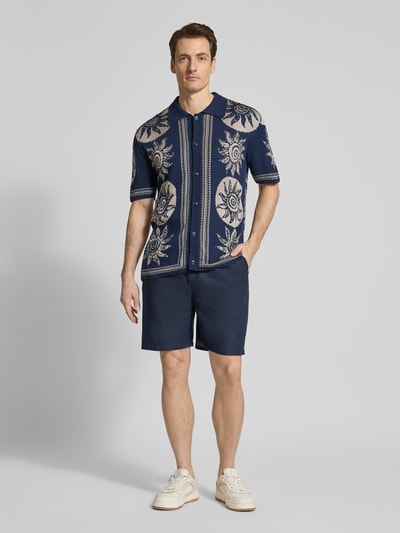 Männermodel trägt Shorts aus Baumwoll-Leinen-Mix Modell 'FAVE' von Scotch & Soda in Dunkelblau, Regular Fit, elastischer Bund, Ganzkörperansicht von vorne.