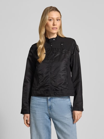 Frauenmodel trägt schwarze Jacke mit Zweiwege-Reißverschluss Modell 'MELBA' von Blauer Usa, figurbetont, Stehkragen, Ganzkörperansicht von vorne.