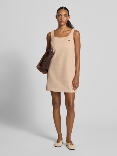 Vrouwenmodel draagt Slim Fit vrijetijdsjurk uit puur katoen van Lacoste in beige, effen en gladde textuur, Ganzelichaamsvoorzijde. Dames vrijetijdsjurk van Lacoste