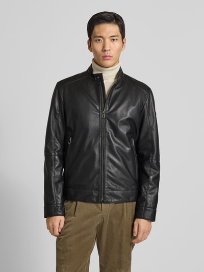Männermodel trägt schwarze Lederjacke mit Reißverschluss Modell 'ASON' von JOOP! Collection aus Lammnappa, Regular Fit, Stehkragen, Reißverschlusstaschen, Ganzkörperansicht von vorne.