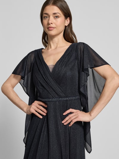 Frauenmodel trägt Maxikleid mit V-Ausschnitt und Ziersteinbesatz von Vera Mont in Glitzer-Optik, taillierte Passform, Volantärmel, Falten-Optik, Farbe Dunkelblau, texturierte Oberfläche; Rückenlänge bei Größe 38: 133 cm, Brustweite: 42 cm, Ärmellänge: 24 cm. Nahaufnahme Oberkörper.
