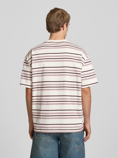 Männermodel trägt T-Shirt mit Logo-Stitching Modell 'EAST LIBERTY' van Dickies, katoen, relaxed fit, ronde hals, ruglengte 68 cm, Ganzkörperansicht Rückansicht.