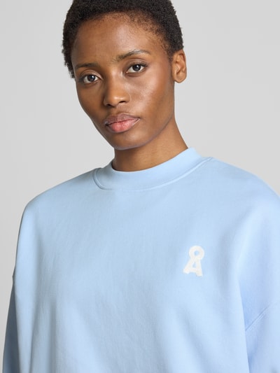 Vrouwenmodel draagt lichtblauw oversized sweatshirt uit katoen model 'ICONIC A ALIZAA' van ARMEDANGELS, dames, close-up bovenlichaam