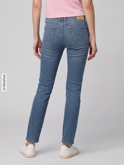 Frauenmodel trägt Skinny Fit Jeans aus Baumwoll-Mix Modell '311 seamed' von Levi's® 300 in Hellblau, glatte Textur, Ganzkörperansicht Rückansicht, KI-modifiziertes Bild.