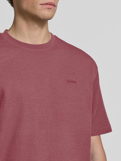 Männermodel trägt Regular Fit T-Shirt aus reiner Baumwolle Modell 'Te_Rib' von BOSS Orange in Rot mit feiner Rippstruktur, Nahaufnahme Oberkörper.