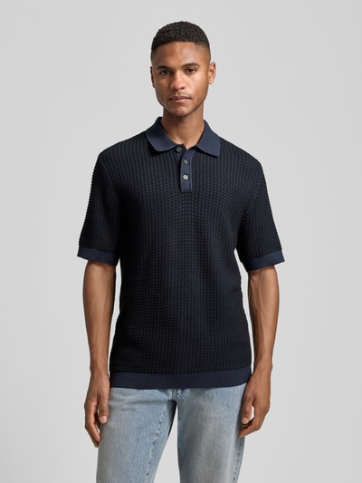 Männermodel trägt Regular Fit Poloshirt in Strick-Optik Modell 'Kingsley' von Jack & Jones Premium, Reine Baumwolle, Kurzärmelig, Polo-Kragen, elastische Abschlüsse, dunkelblaue Farbe, strukturierte Oberfläche, Rückenlänge bei Größe M 77 cm, Ganzkörperansicht von vorne.