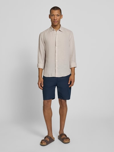 Männermodel trägt Regular Fit Freizeithemd aus reinem Leinen Modell 'REGKYLIAN' von SELECTED HOMME in Beige, unifarben, Ganzkörperansicht von vorne.