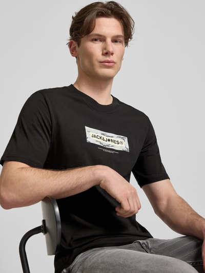 Männermodel trägt T-Shirt mit Logo und Rundhalsausschnitt von Jack & Jones in Schwarz, Reine Baumwolle, Regular-Fit, Nahaufnahme Oberkörper.