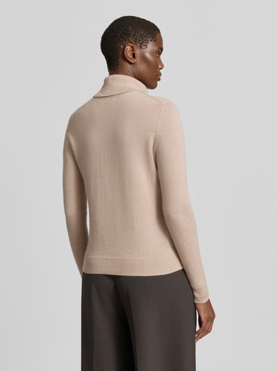 Frauenmodel trägt Regular Fit Rollkragenpullover aus reinem Kaschmir von Christian Berg Woman in Beige mit gerippten Abschlüssen, Ganzkörperansicht Rückansicht.