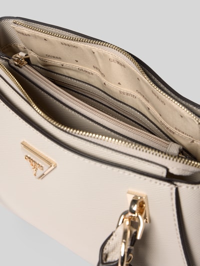 Produktfoto, beige strukturierte Handtasche mit goldener Label-Applikation, Reißverschluss, Guess Modell 'NOELLE II', Detailaufnahme, sichtbares Hauptfach, Innenfutter mit Markenlogo, Tragehenkel und Schulterriemen