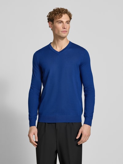 Männermodel trägt Strickpullover aus Woll-Mix mit V-Ausschnitt von Christian Berg Men in Blau, Regular Fit, Ganzkörperansicht von vorne.